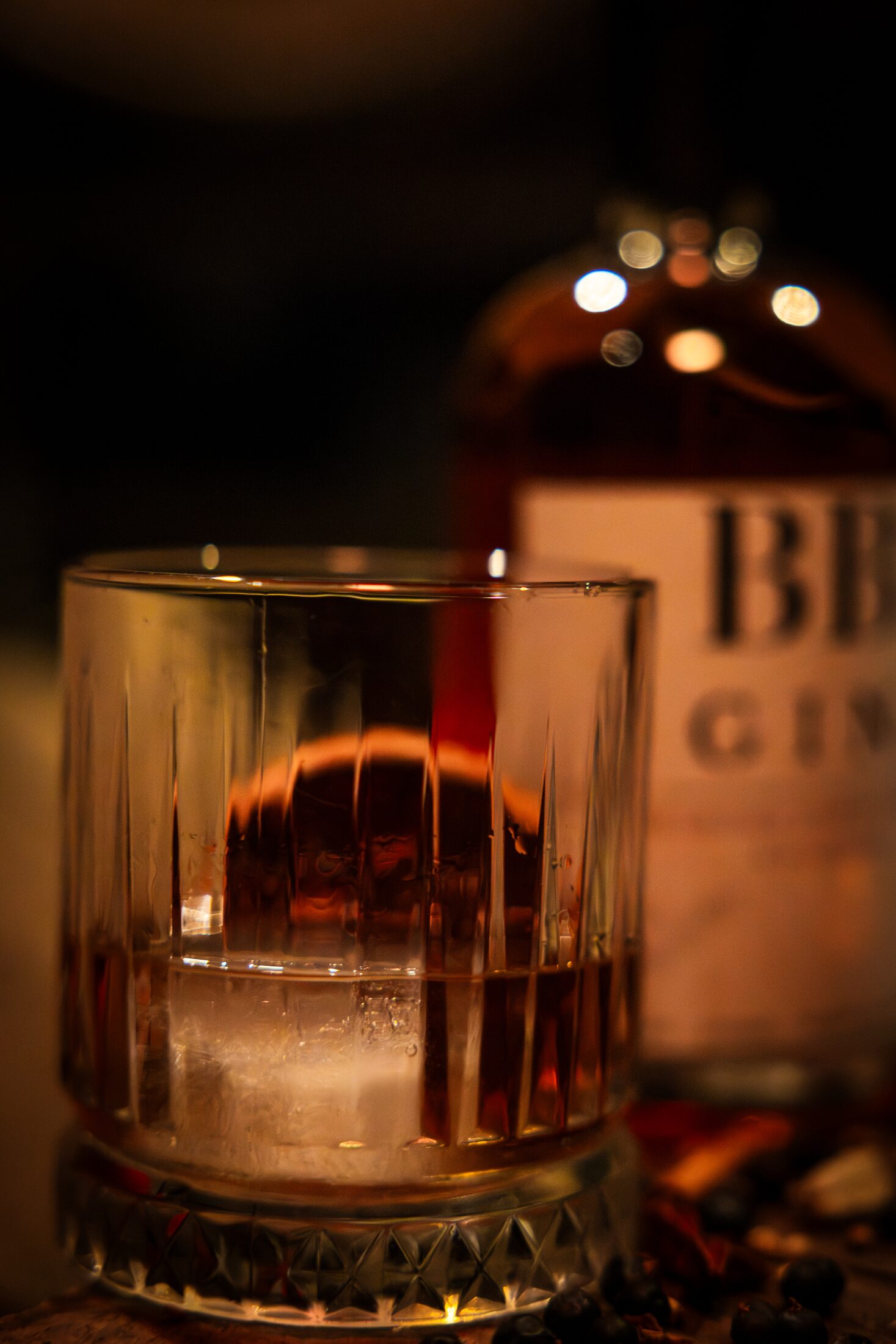 A tumbler of gin over a large ice sphere