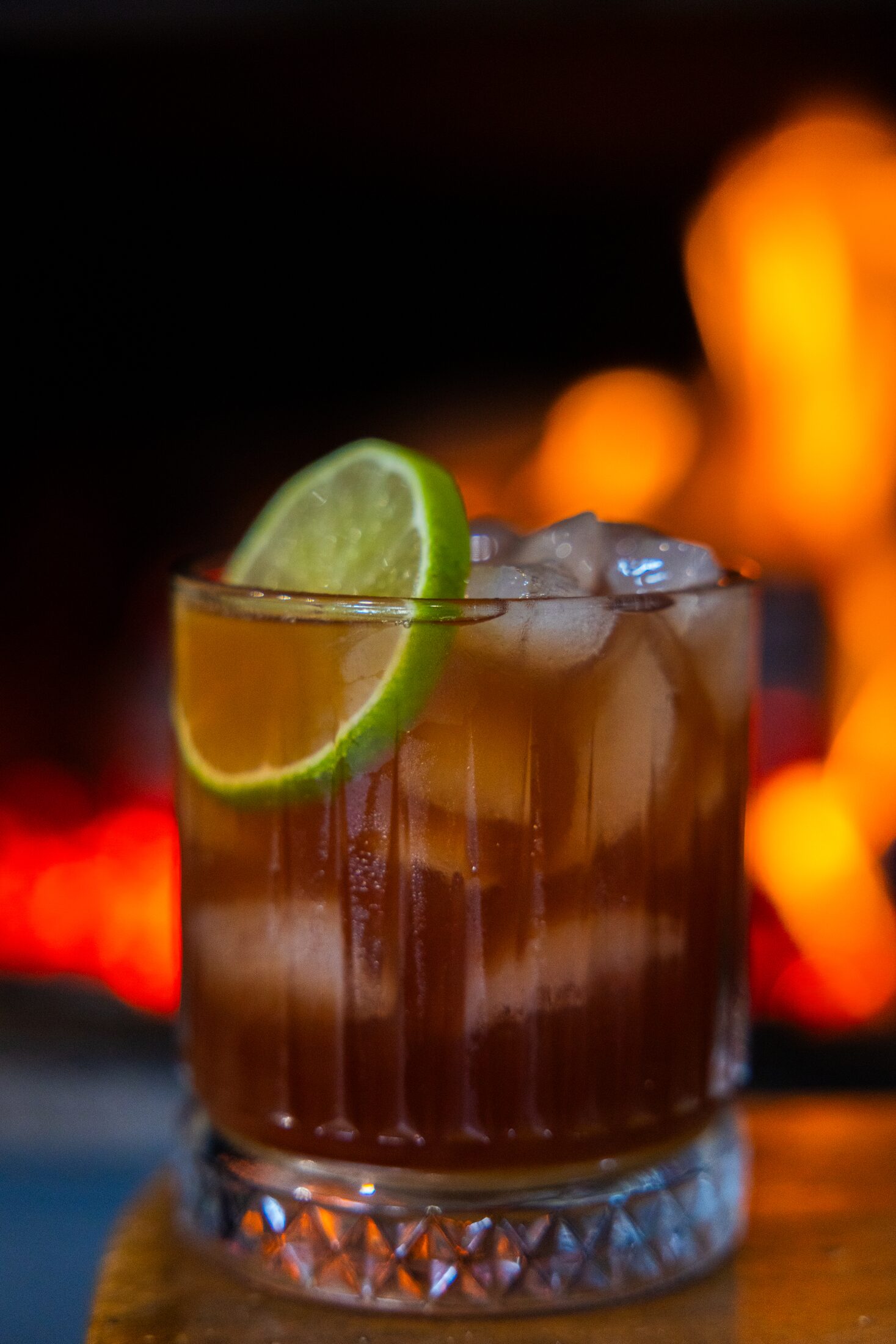 A gin and tonic with lime by the fire