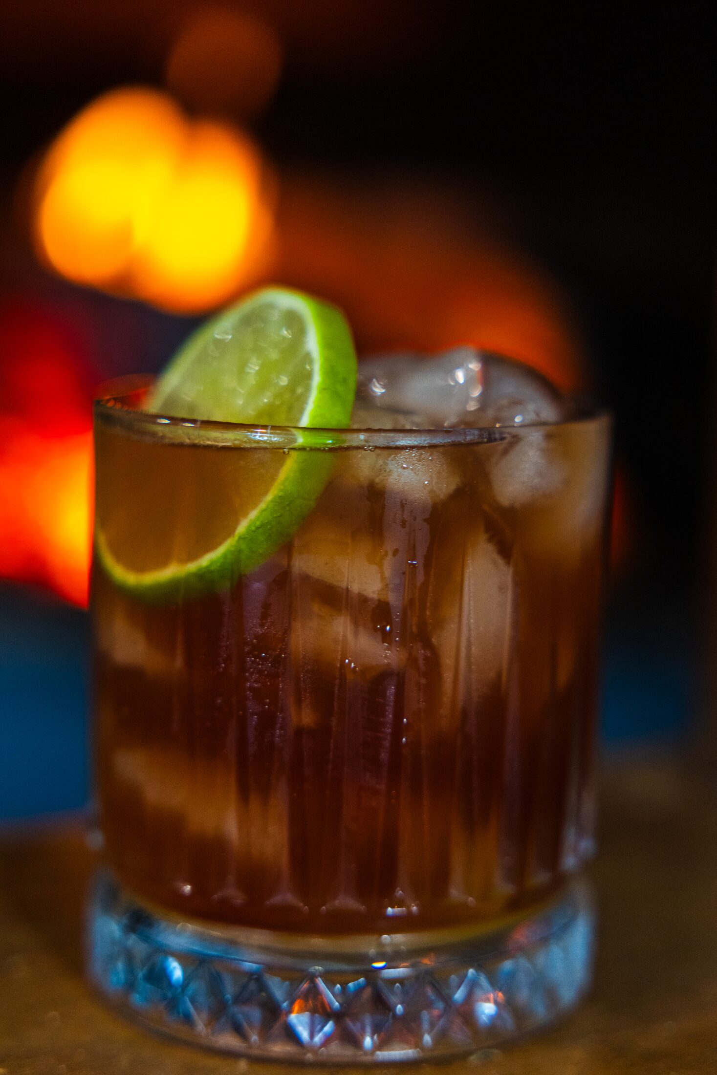 A gin highball with lime by the fire